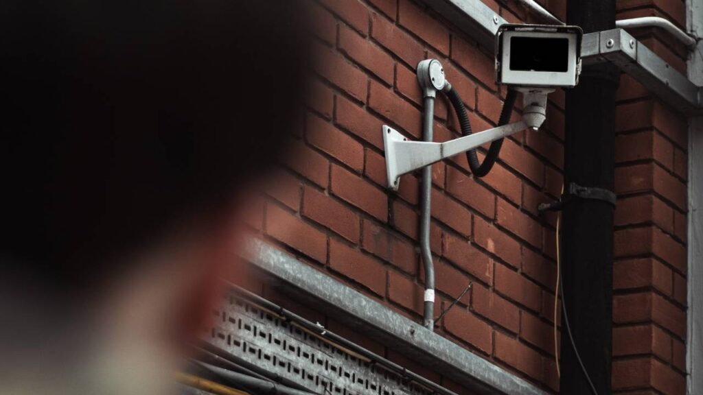 A photo of a blurred man staring at a CCTV camera