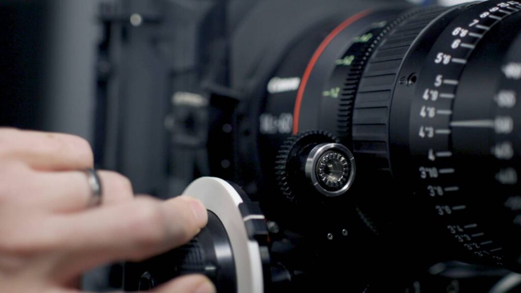A photo of a hand adjusting a knob on a modern camera