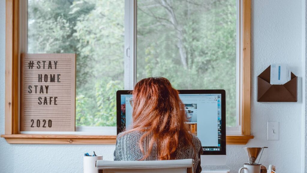 A redhead woman working remotely from her home