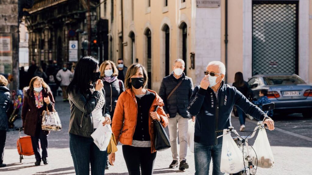 A group of people with face masks walking the street