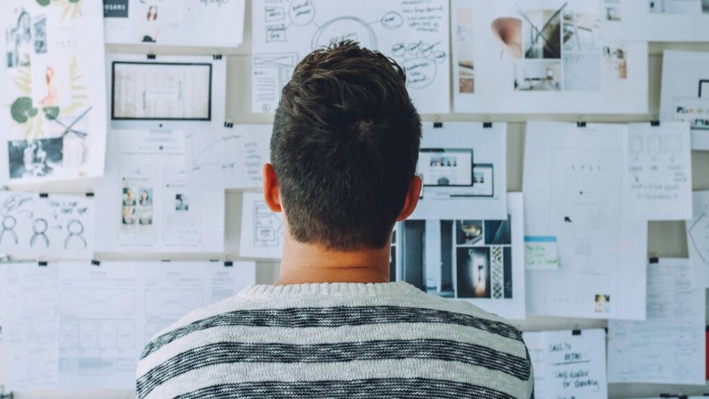 A man looking at papers on a whiteboard