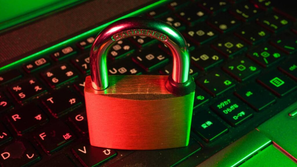A large, golden-coloured lock placed on a black laptop keyboard